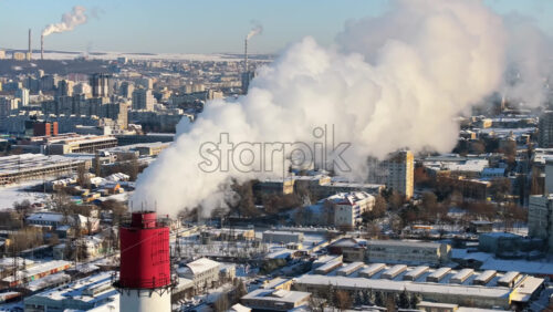 Video - Aerial drone view of a working thermal power station in Chisinau city covered in snow. Steam and smoke coming from pipes. Moldova