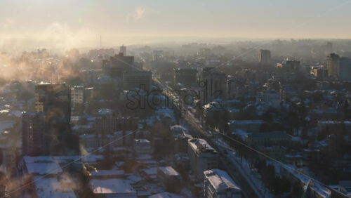 Video - Aerial drone view of Chisinau city covered in snow at sunset. Clouds in foreground. Winter in Moldova