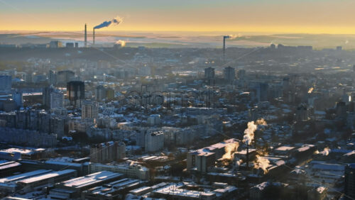 Video - Aerial drone view of Chisinau city covered in snow at sunset. Working thermal power station in background. Winter in Moldova