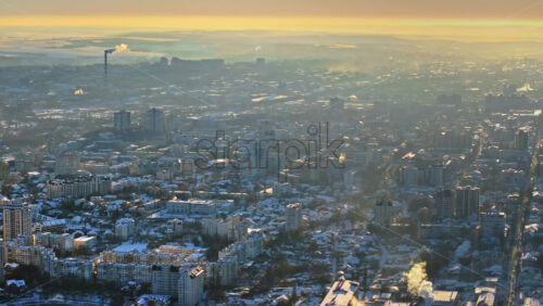 Video - Aerial drone view of Chisinau city covered in snow at sunset. Working thermal power station in background. Winter in Moldova