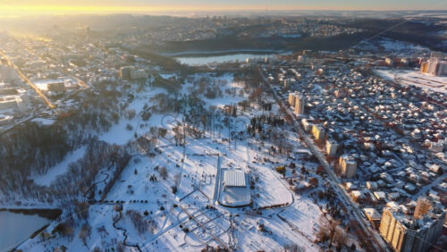 Video - Aerial drone view of the city park covered in snow. Sunrise during winter in Chisinau, Moldova