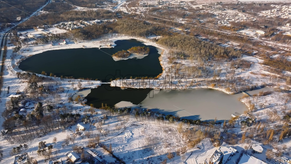 Video - Aerial drone view of a lake in winter at sunrise. The ground covered by snow in Chisinau, Moldova