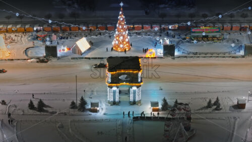 Video - Aerial drone view of Chisinau city center covered in snow at night. The Triumphal Arch surrounded by Christmas winter decorations. Moldova