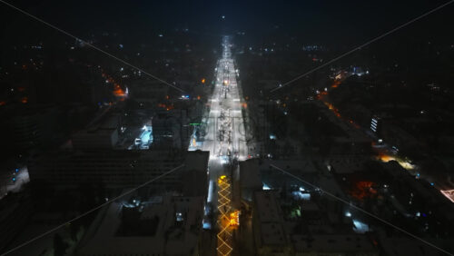 Video - Aerial drone view of Chisinau city covered in snow at night, blue hour. Moldova