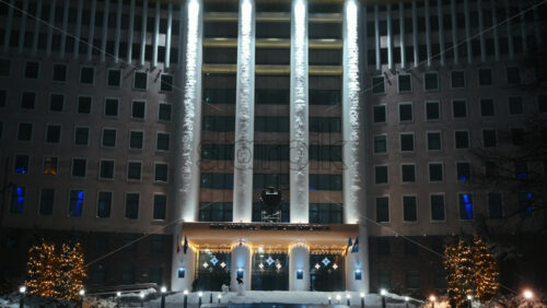 Video - Parliament of the Republic of Moldova with national emblem, illumination and Christmas decorations in the evening. Ground covered in snow. Winter in Chisinau