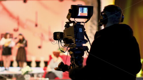 Video - Man filming with professional camera on the backstage of a TV set