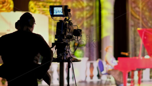 Video - Man filming with professional camera on the backstage of a TV set