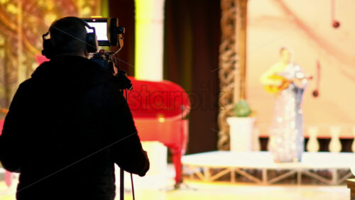 Video - Man filming with professional camera on the backstage of a TV set