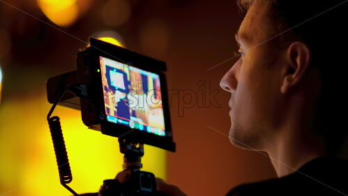 Video - Man filming with professional camera on the backstage of a TV set