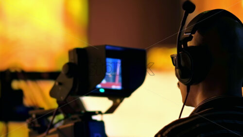 Video - Man filming with professional camera on the backstage of a TV set