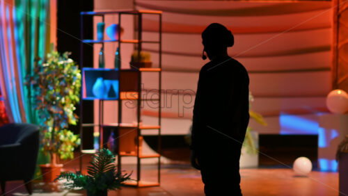 Video - Silhouette of the director of photography with an audio headset in a television studio. Backstage of the preparation for the show