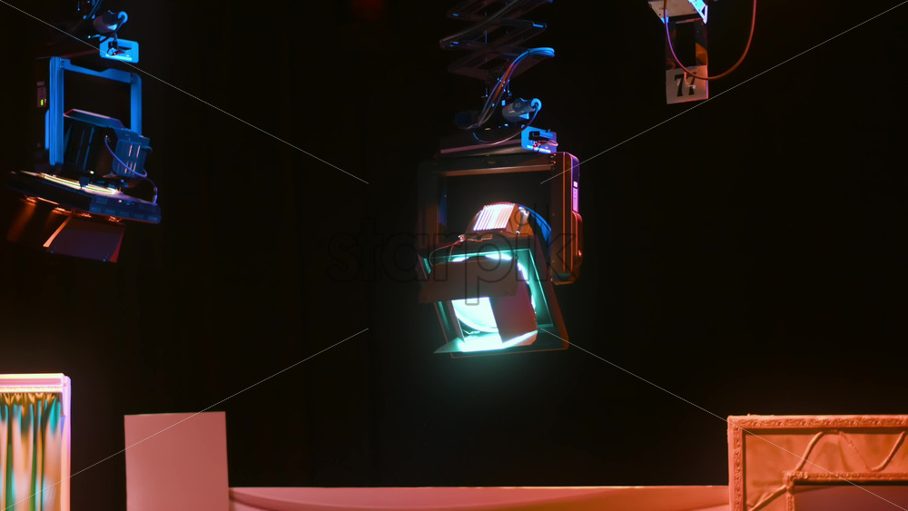 Video - Grid of professional lighting fixtures suspended in a dark television studio