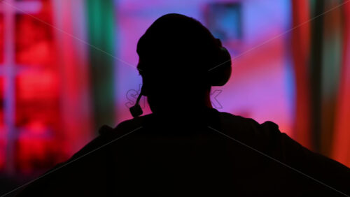 Video - Silhouette of the director of photography with an audio headset in a television studio. Backstage of the preparation for the show