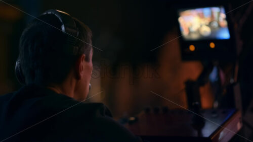 Video - Cameraman filming a television talk show on a professional camera mounted on the crane. Video production backstage in a dark studio