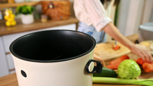 Video - Young woman recycling vegetables peels in a compost bin. Housewife cooking food and composting organic waste in a bokashi container at home. Ecological and sustainability concept