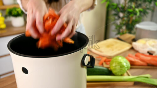Video - Young woman recycling vegetables peels in a compost bin. Housewife cooking food and composting organic waste in a bokashi container at home. Ecological and sustainability concept