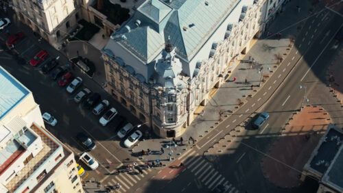 Video - Aerial drone top view of a downtown old historical building in the sunlight. Moving traffic in Bucharest, Romania