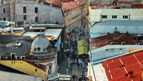 Video - Bucharest, Romania - March 03, 2024: Walking people among old historical buildings and commercial shops in the old town