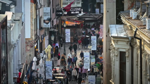 Video - Bucharest, Romania - March 03, 2024: Walking people among old historical buildings and commercial shops in the old town
