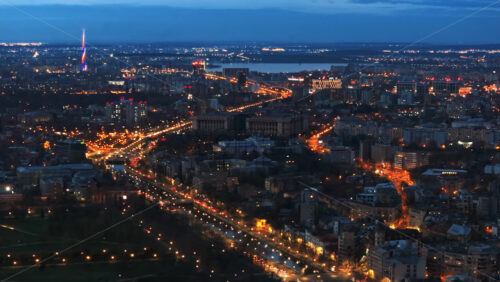 Video - Aerial drone view of illuminated Bucharest cityscape in the evening. Moving traffic. Blue hour, Romania