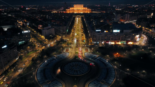 Video - Bucharest, Romania - March 03, 2024: Aerial drone view of the city downtown. Roundabout intersection with moving cars and fountains. Palace of the Parliament in the distance