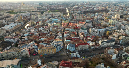 Video - Bucharest, Romania - March 03, 2024: Aerial drone view of the cityscape with moving traffic at sunset