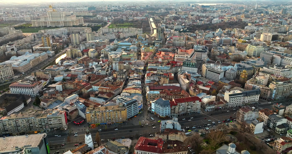 Video - Bucharest, Romania - March 03, 2024: Aerial drone view of the cityscape with moving traffic at sunset