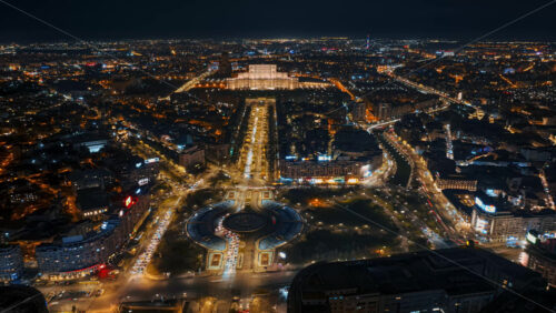 Video - Aerial hyperlapse timelapse drone view of illuminated Palace of the Parliament in city downtown in the night. Multiple districts around