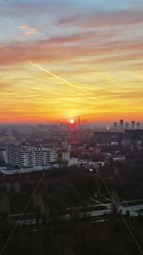 Video - Vertical aerial drone view of Bucharest city at sunset. Flying birds. Romania