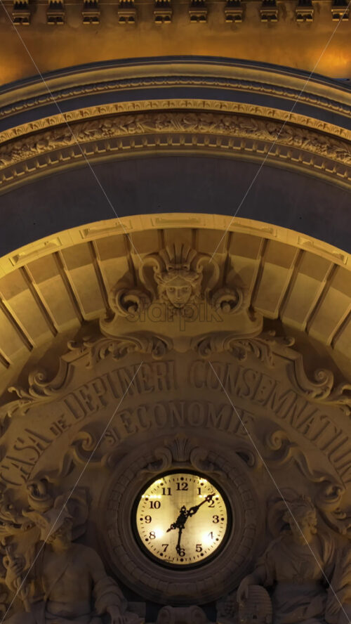 Video - Vertical aerial drone view of the illuminated Palace of the Deposits and Consignments in the evening. Blue hour in Bucharest, Romania