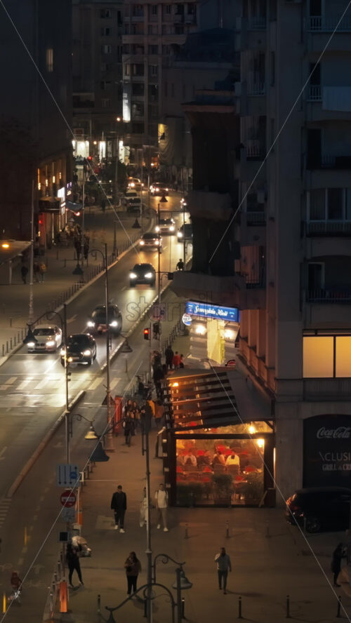 Video - Bucharest, Romania - March 03, 2024: Vertical aerial drone view of illuminated road with moving traffic in the evening. Blue hour