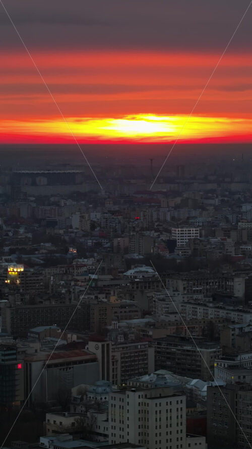 Video - Vertical aerial drone view of Bucharest city at sunset. Moving traffic. Romania