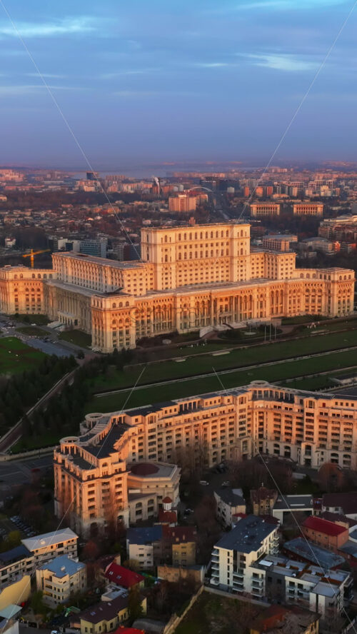 Video - Vertical aerial drone view of Palace of the Parliament in Bucharest downtown at sunset. Blue hour. Romania