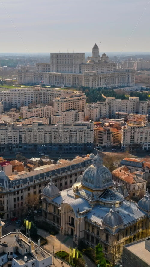 Video - Bucharest, Romania - March 03, 2024: Vertical aerial drone view of Palace of the Parliament in the city center. Sunny day