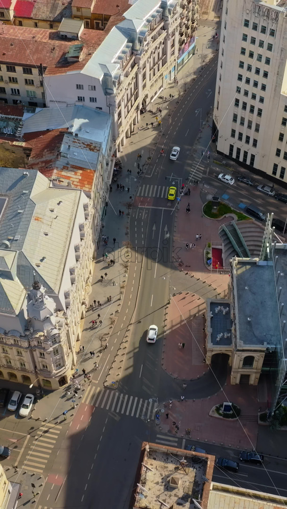 Video - Vertical aerial drone top view of the city center with moving traffic in sunlight. Bucharest, Romania