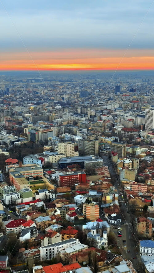 Video - Vertical aerial drone view of Bucharest city at sunset. Moving traffic. Romania