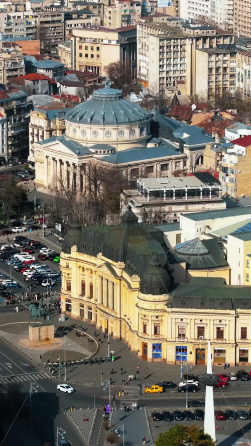 Video - Bucharest, Romania - March 03, 2024: Vertical aerial drone view of Carol I University Foundation. Main building with Carol I statue in front of it, roads and buildings