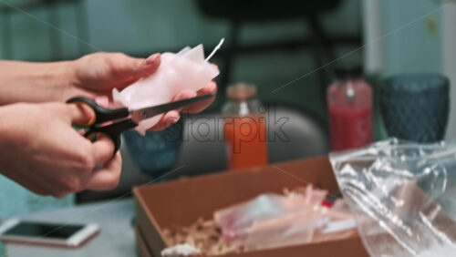 Video - A woman occupied with hand made candles production, preparing a mold for wax