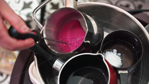 Video - Hand made candles production, female hand checking temperature of melting wax in pots. Slow motion