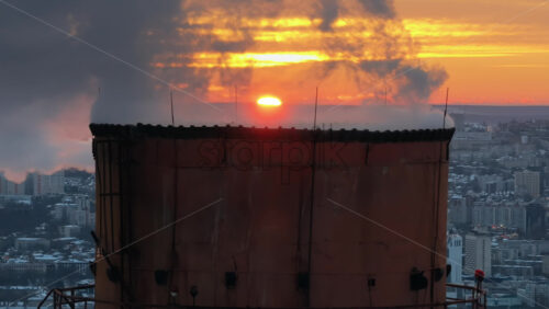Video - Aerial drone view of a working thermal power station in Chisinau at sunset. Steam and smoke coming from pipes. Moldova