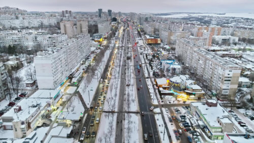 Video - Chisinau, Moldova - January 15, 2024: Aerial drone view of the city covered in snow with moving traffic