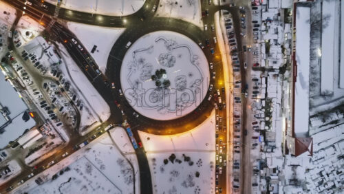 Video - Aerial drone top view of Chisinau city covered in snow with moving traffic in the evening. Winter in Moldova