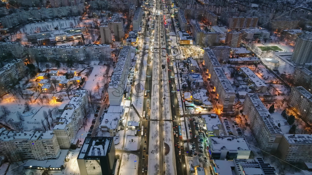 Video - Aerial drone view of Chisinau city covered in snow with moving traffic in the night. Blue hour during winter in Moldova