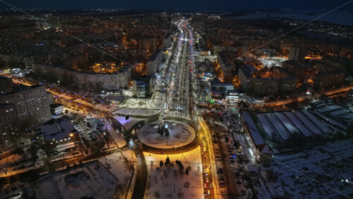 Video - Aerial drone view of Chisinau city covered in snow with moving traffic in the night. Blue hour during winter in Moldova