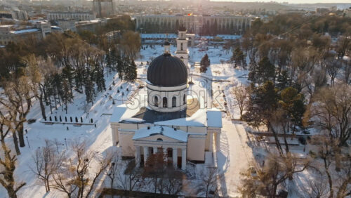 Video - Aerial drone view of the Bell tower and the Metropolitan Cathedral of Christ's Nativity. City center covered in snow at sunset in Chisinau, Moldova