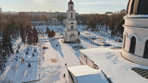 Video - Aerial drone view of the Bell tower and the Metropolitan Cathedral of Christ's Nativity. City center covered in snow at sunset in Chisinau, Moldova