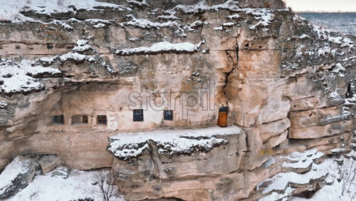 Video - Aerial drone view of the cave monastery in Old Orhei at sunrise. City covered in snow. Moldova