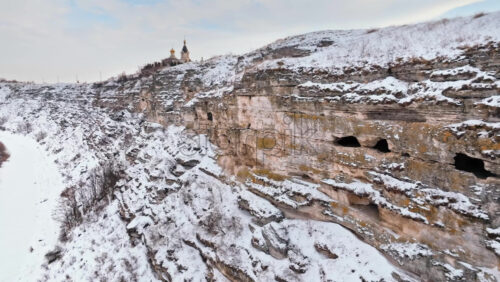 Video - Aerial drone view of the cave monastery in Old Orhei at sunrise. City covered in snow. Moldova