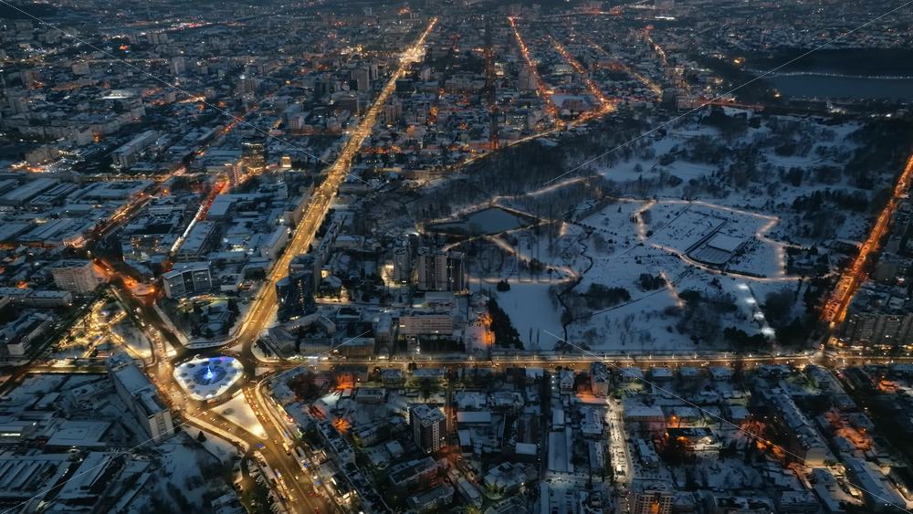 Video - Aerial drone view of Chisinau city covered in snow with moving traffic in the evening, blue hour. Winter in Moldova