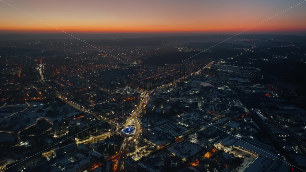 Video - Aerial drone view of Chisinau city covered in snow with moving traffic at sunset. Winter in Moldova